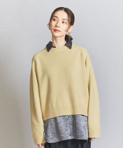 ニットとシャツを着る女性