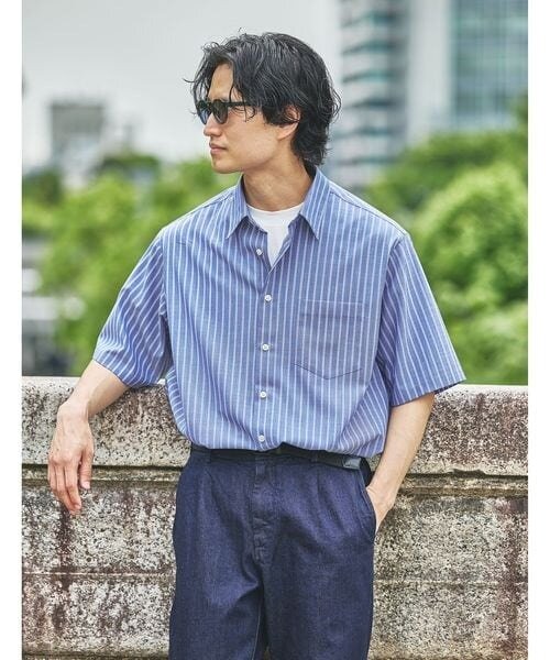 青シャツとデニムをあわせたコーデの男性