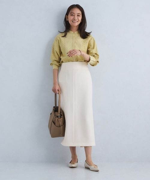 ハイウエストの白スカートを着た女性