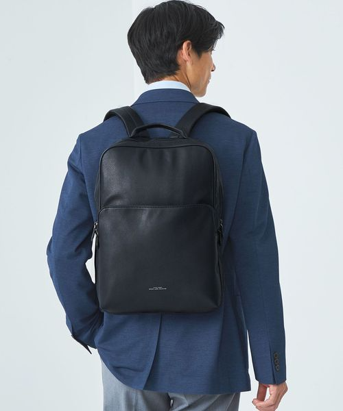 スーツにレザーライクのビジネスバッグを背負った男性