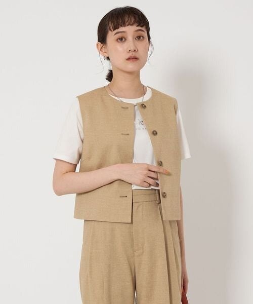 ベージュのジレを着た女性