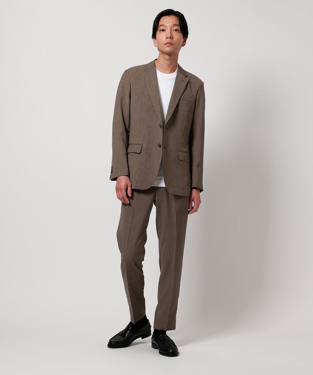 スーツにコインローファーをはいた男性