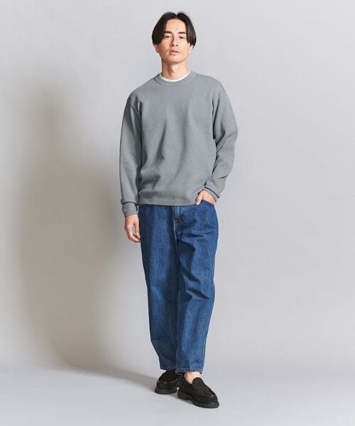 グレーのニットにデニムをあわせたコーデ