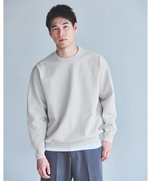 ライトグレーのニットにシャツをレイヤードしたコーデ