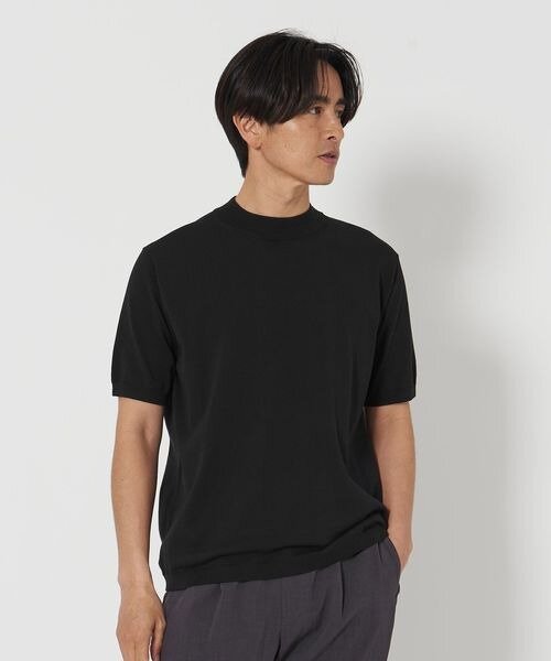 フィット感のある黒ニットを着た男性