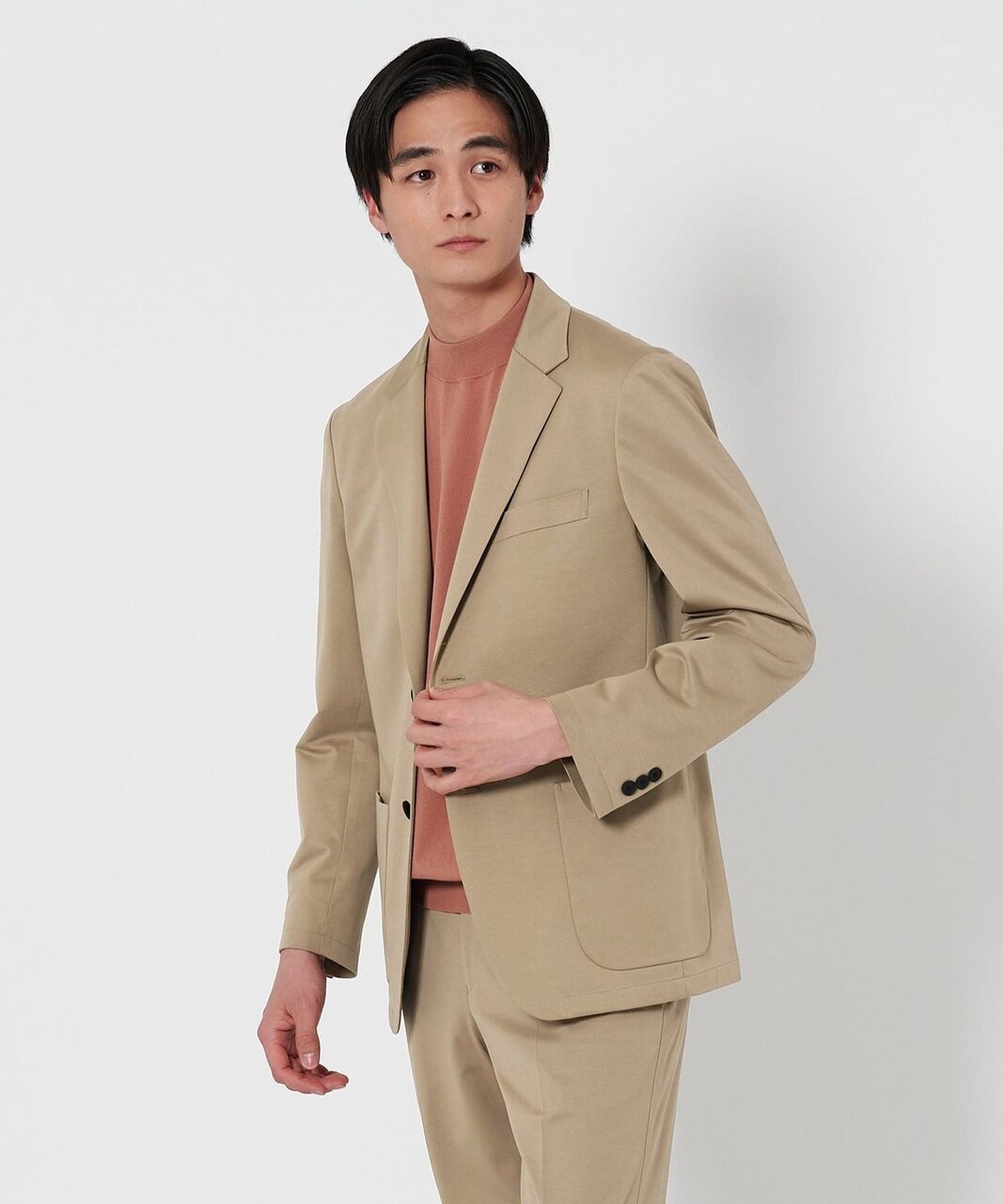 ジャケットとスラックスのセットアップを着た男性