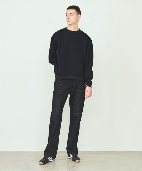 ダークカラーのデニムパンツをはいた男性