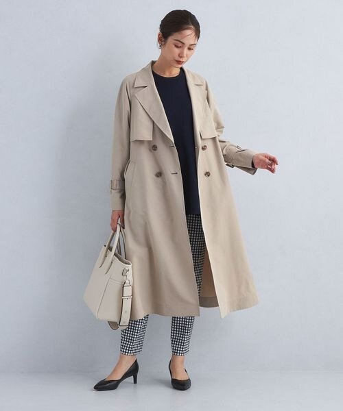 モカカラーのトレンチコートを着用している女性