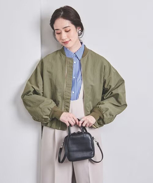オリーブ色のブルゾンを着た女性