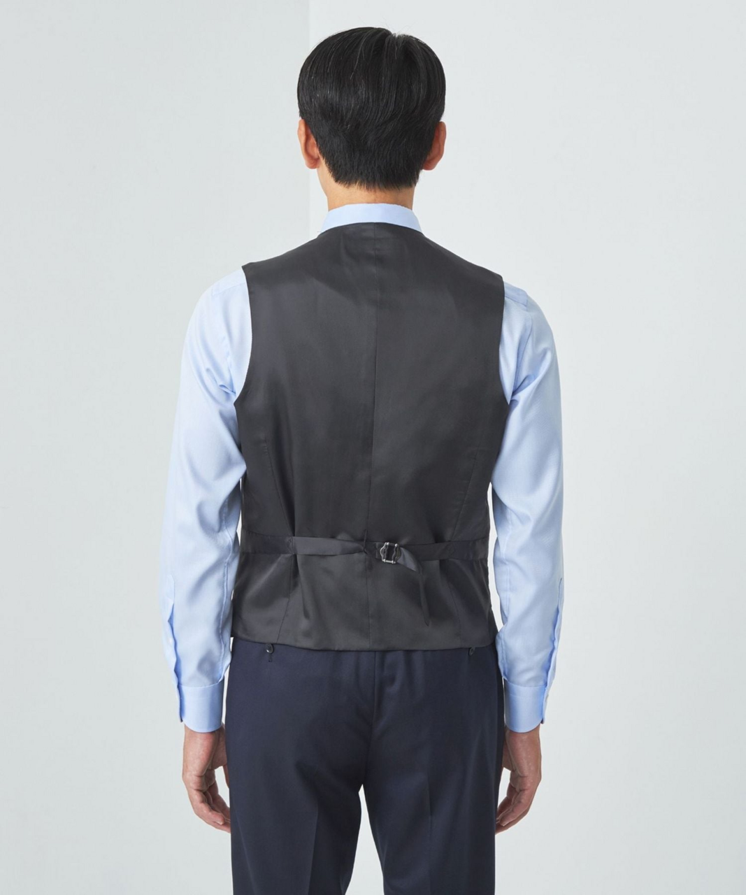 ベストを着て後ろを向いた男性