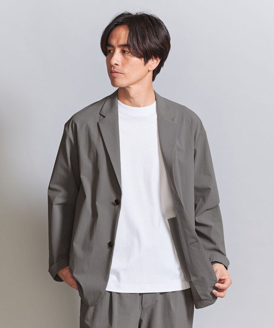 セットアップのインナーにTシャツを着た男性