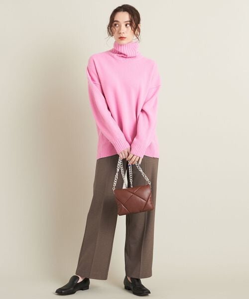 ピンクのトップス×茶色のパンツの女性