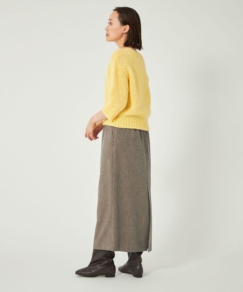 イエローのニット×茶色のスカートを着用した女性