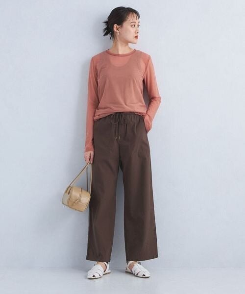 ピンクのニット×茶色のスカートを着用した女性