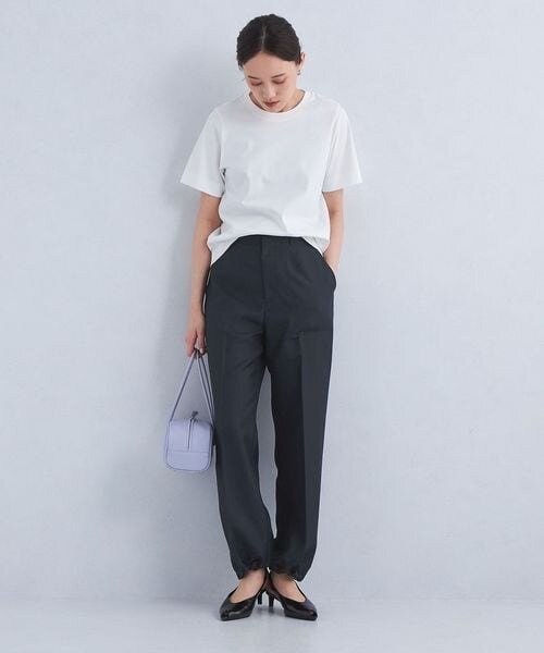 白のTシャツ×ネイビーのパンツを着用している女性