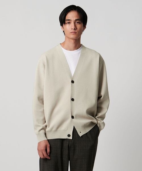 ナチュラルカラーのカーディガンを着た男性