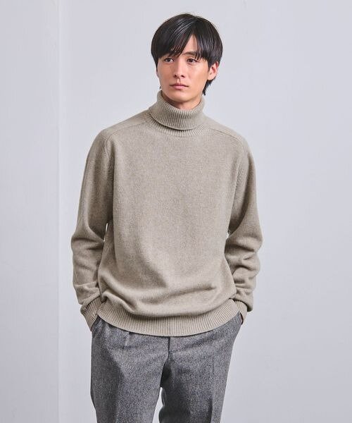 ベージュのニットを着た男性