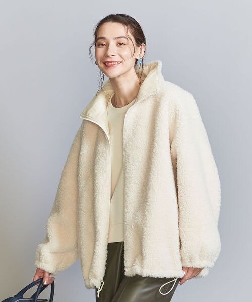 ホワイトのボアブルゾンを着た女性