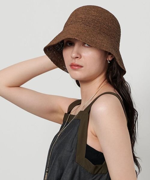 ラフィア素材のバケットハットをかぶった女性