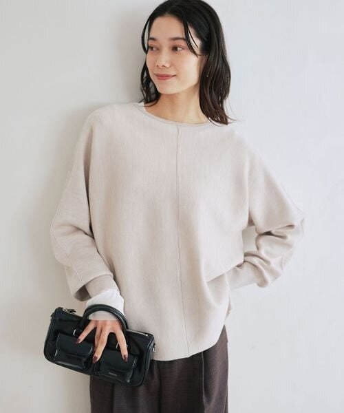 ベージュのニットを着た女性