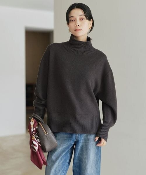 ハイネックのニットを着た女性