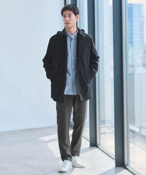 シャツにステンカラーコートを着た男性