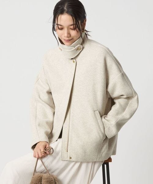 ショート丈のコートを着用する女性