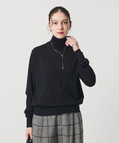 ハイネックのニットを着用する女性