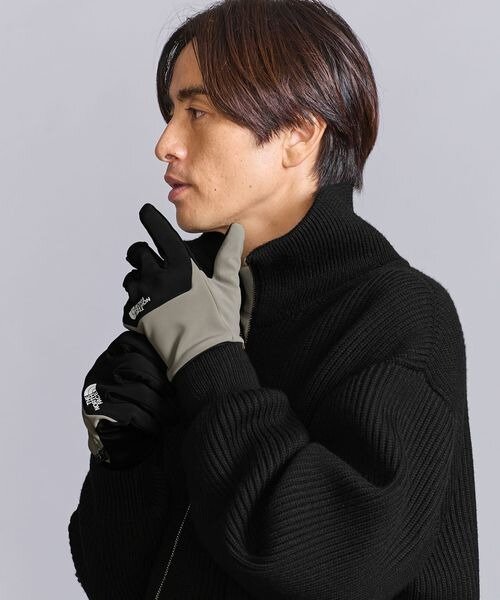 黒のアウターに手袋をした男性