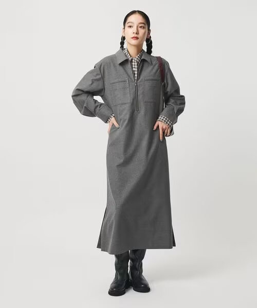 グレーのデザインワンピースを着た女性