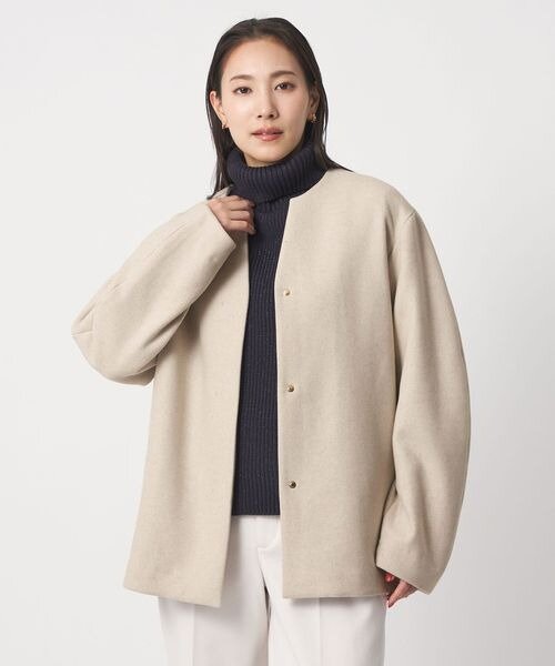 ショート丈のコートを着用する女性