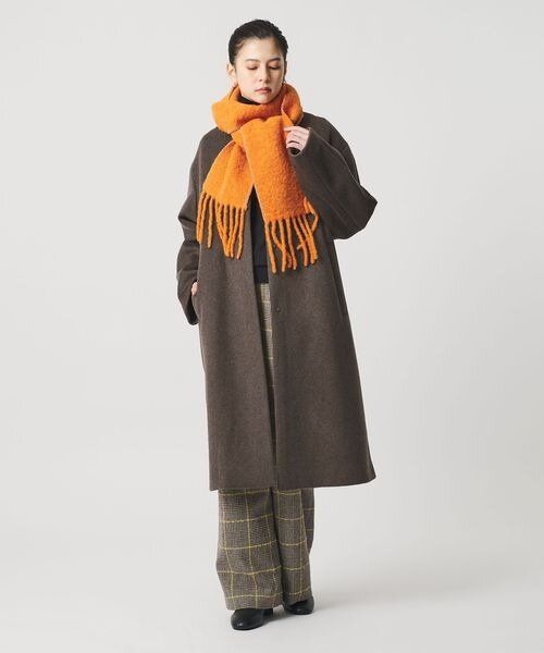 ロング丈のコートを着用する女性