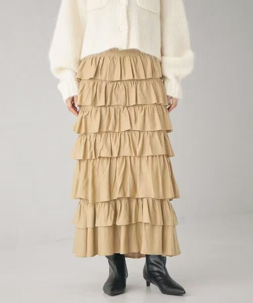 ベージュのティアードスカートをはいた女性