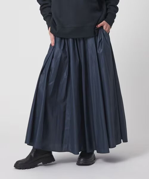 ネイビーのギャザースカートをはいた女性