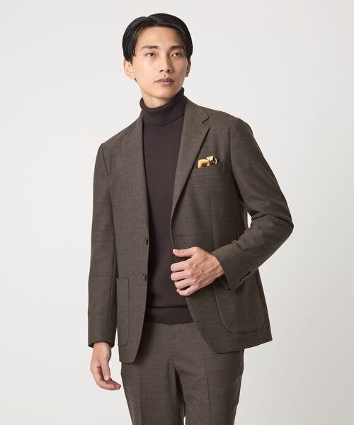 ノータイのスーツにチーフを挿した男性