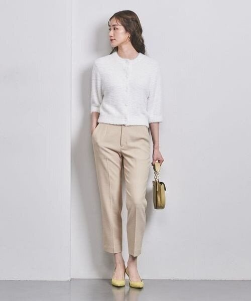 ベージュのテーパードパンツをはいた女性