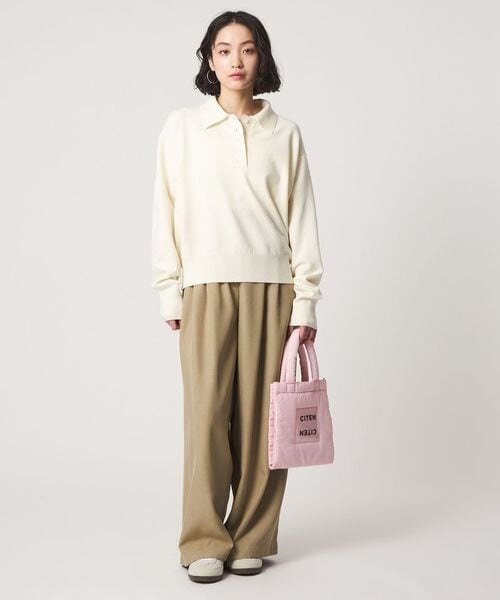 ベージュのワイドパンツをはいた女性