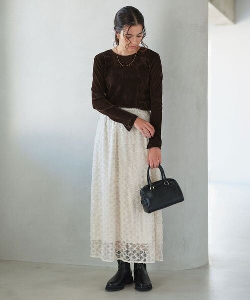 フェミニンなスカートをシックに着こなす女性