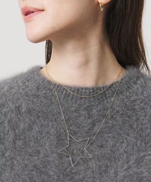 星モチーフのネックレスをつけた女性