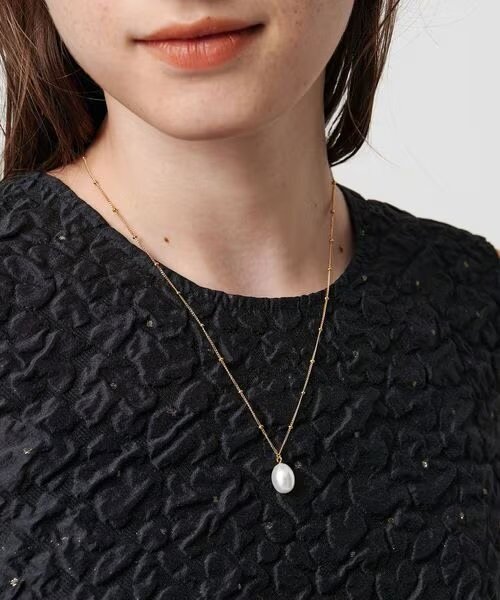 一粒パールのネックレスをつけた女性