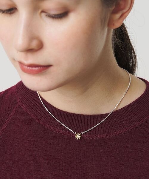 フラワーモチーフの3WAYネックレスをつけた女性