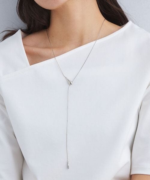 しずくモチーフのチェーンネックレスをつけた女性