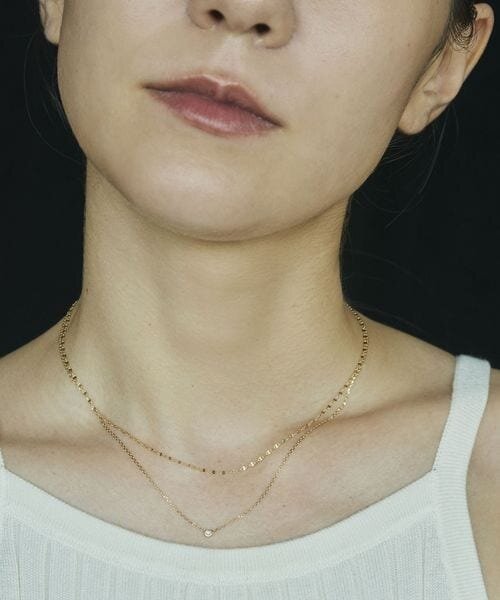 一粒ダイヤのネックレスをつけた女性