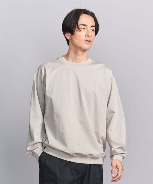 ナチュラルカラーのロングTシャツを着用している男性