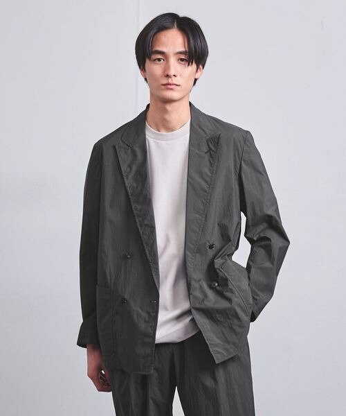 黒のダブルジャケットを着用している男性