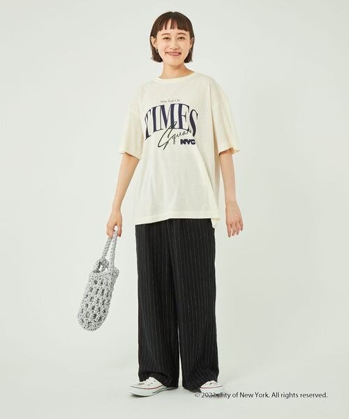 ロゴTシャツとワイドパンツを着用した女性