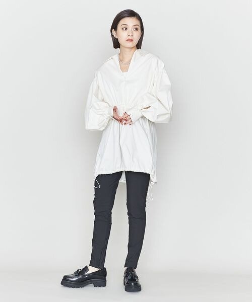 黒のテーパードパンツをはいた女性