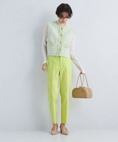 イエローのテーパードパンツをはいた女性