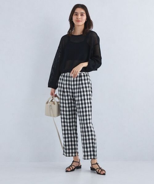 チェック柄のテーパードパンツをはいた女性