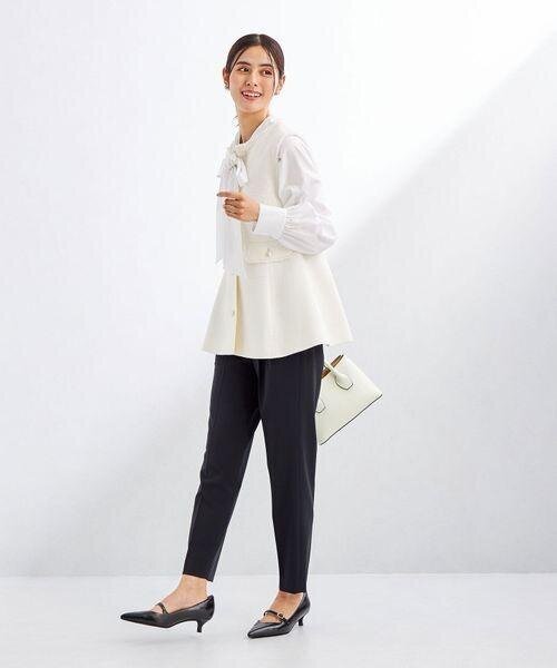 黒のテーパードパンツをはいた女性